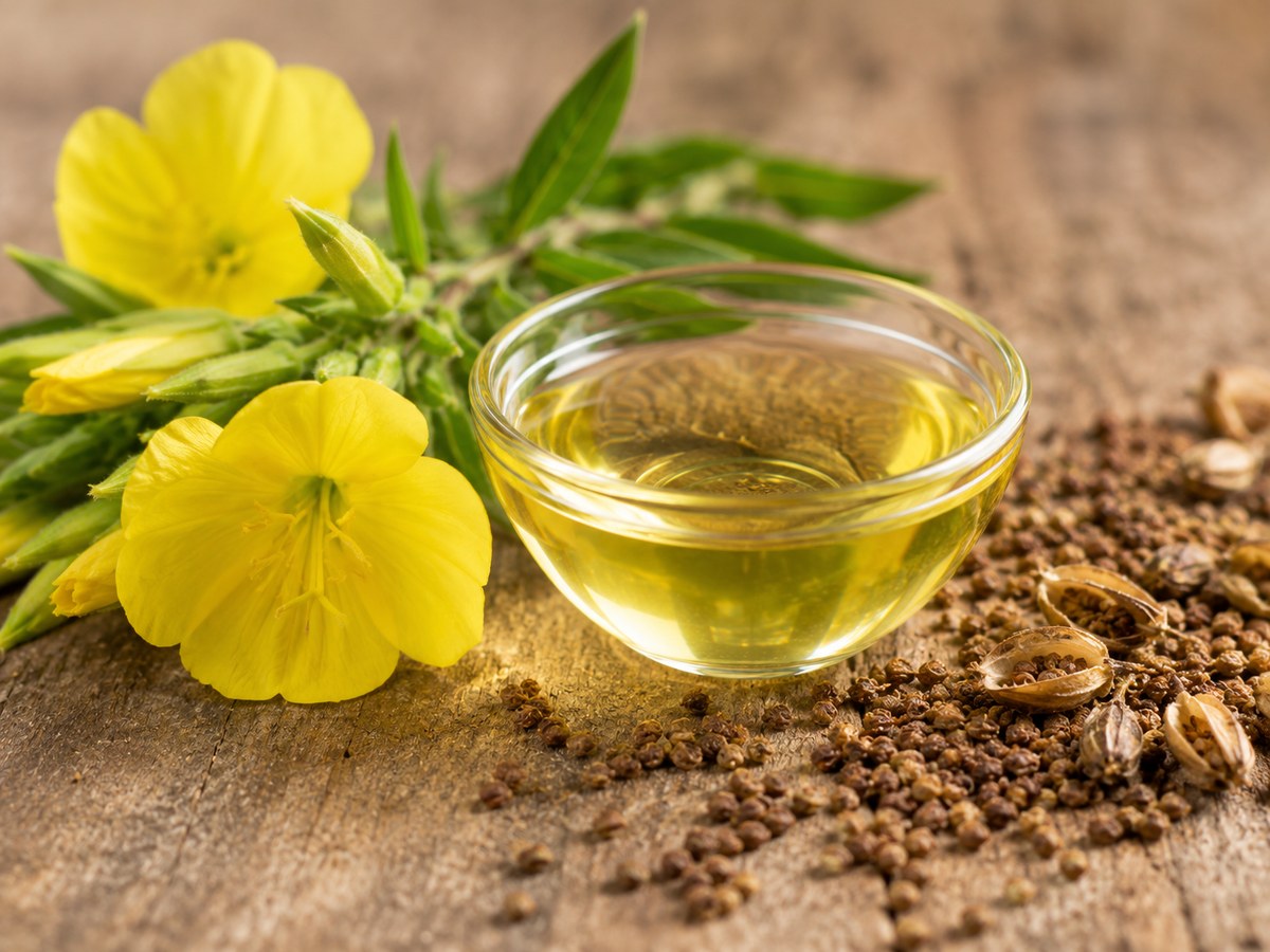 Evening primrose flowers beside a bowl of oil and seeds